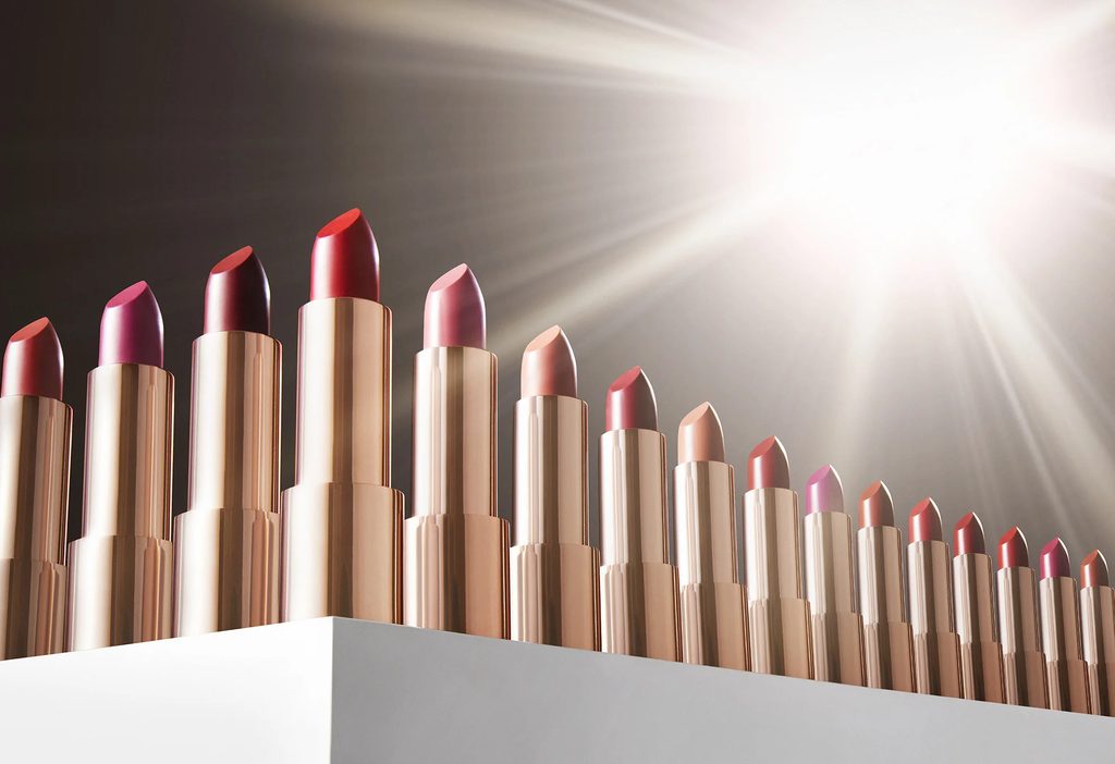 Rose gold lipsticks arranged in a sculpted row under studio light